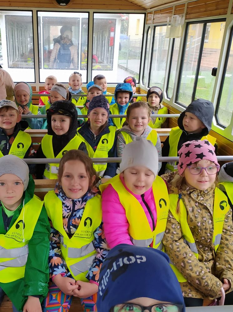 19 dzieci pozuje do zdjęcia we wnętrzu wagonika Krośnieńskiej kolejki.