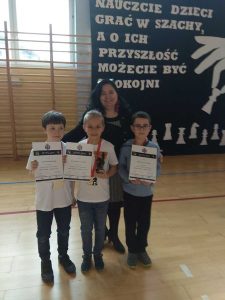 Kobieta i trzej chłopcy z dyplomami laureatów konkursu