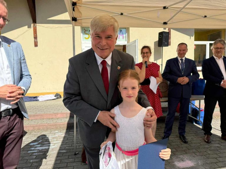 Dziewczynka, która dostała nagrodę pozuje do zdjęcia z panem prezydentem.