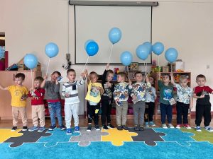 Grupa chłopców pozuje do zdjęcia. W rękach trzyma prezenty.