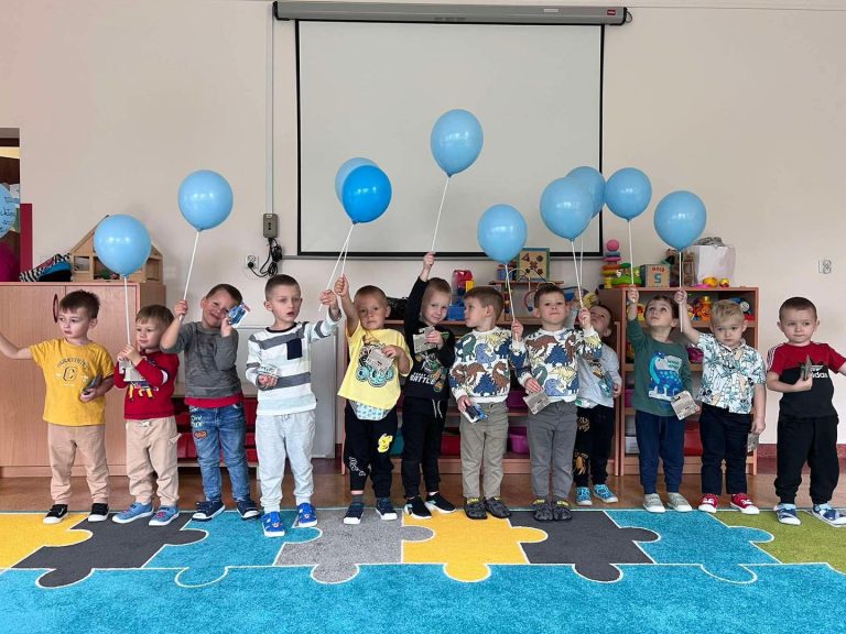 Grupa chłopców pozuje do zdjęcia. W rękach trzyma prezenty.