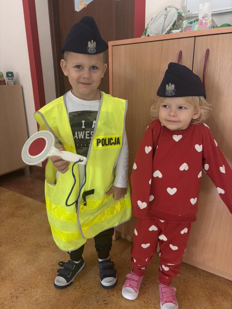 Dwoje dzieci pozuje do zdjęcia przebrani za policjantów.