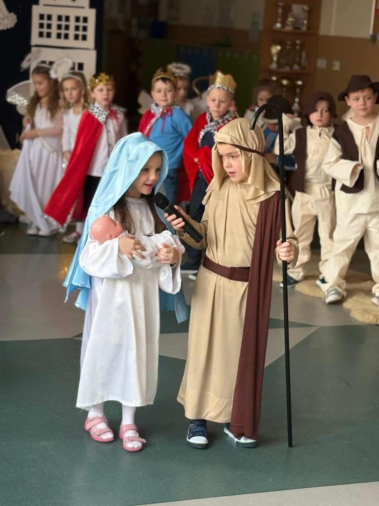 Dzieci przebrane za Maryję i Józefa mówią swoje kwestie. W tle widać innych aktorów.